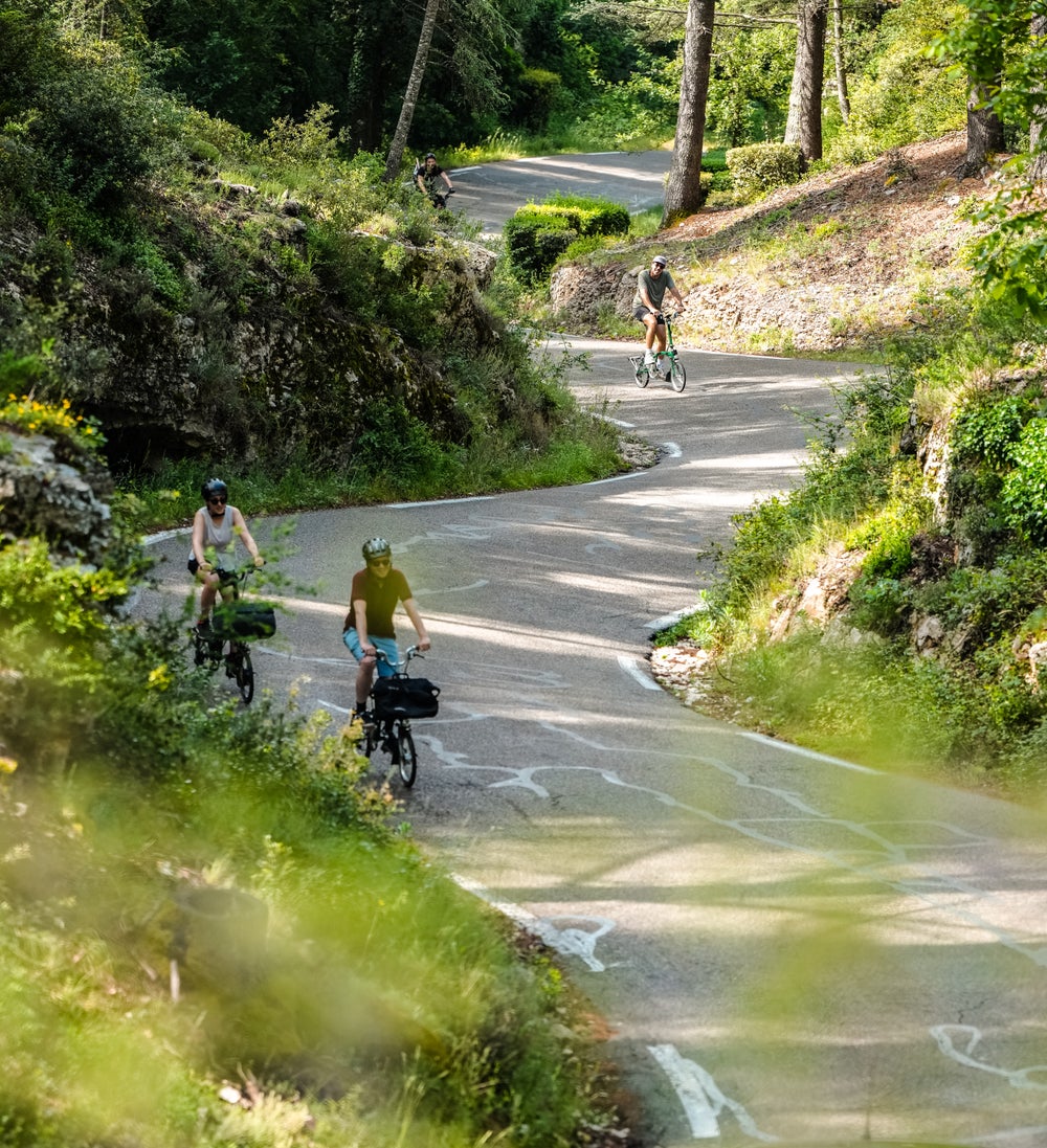 A scenic shot of Brompton riders on a winding road