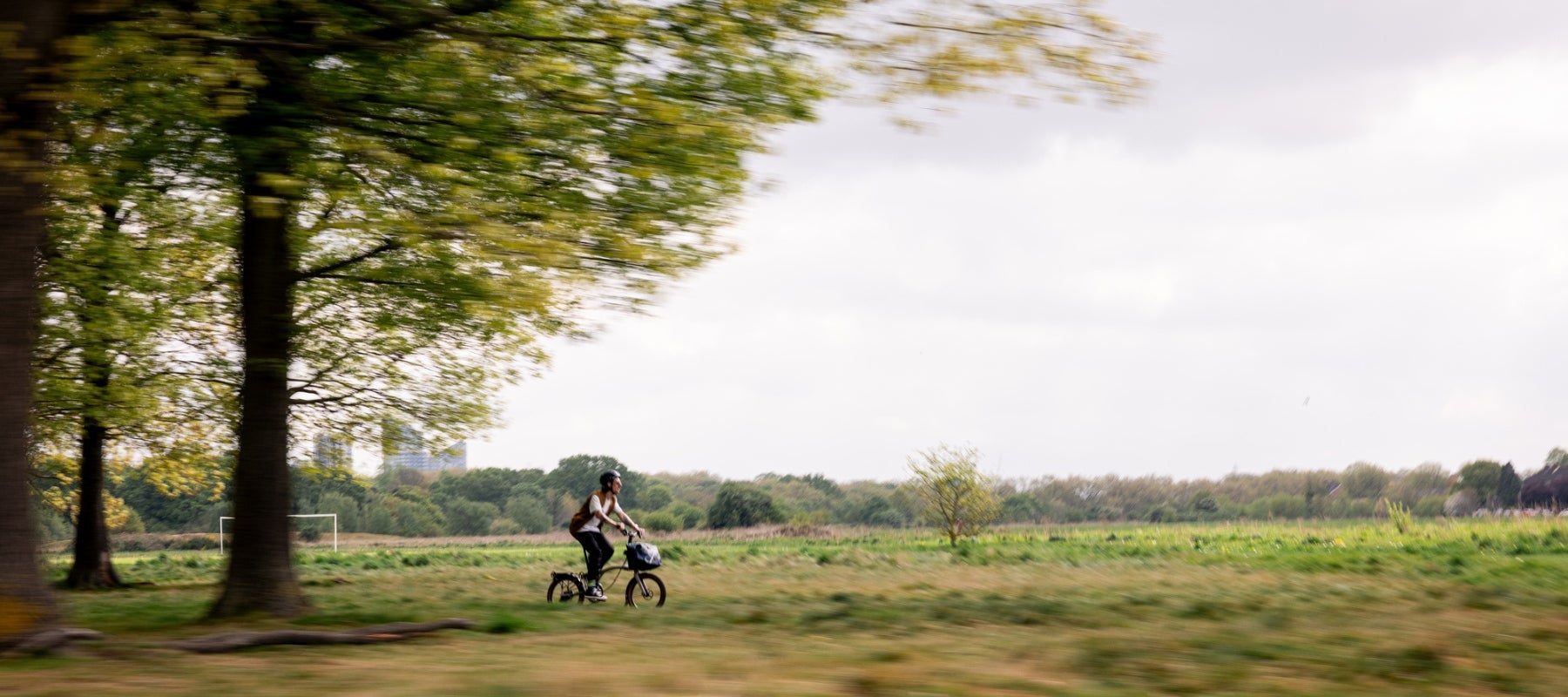 Man riding away from city through a park on G Line