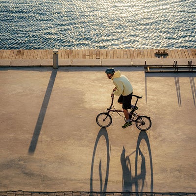 Man riding bike along seafront