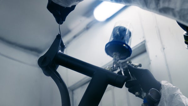 Person spaying Brompton bike frame