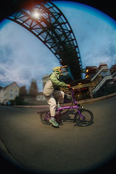 Person riding Pop Lilac Brompton bike