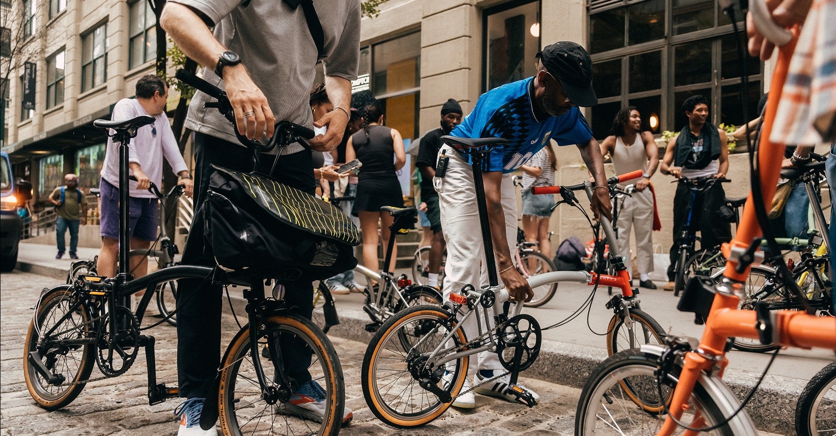 People standing in a crowd with Brompton bikes