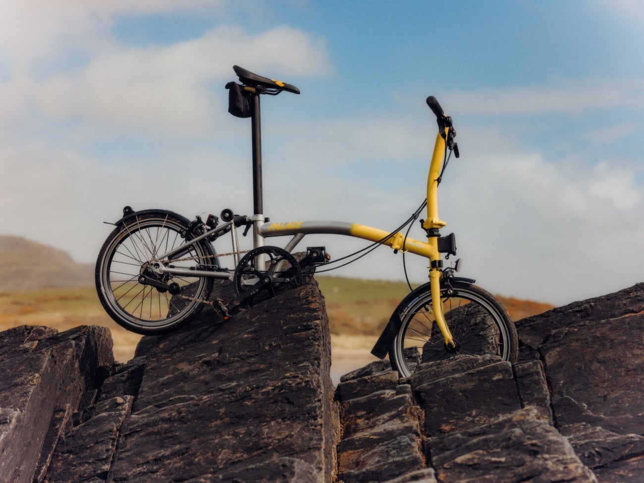 Le vélo pliant Brompton de Palace sur les rochers de la plage