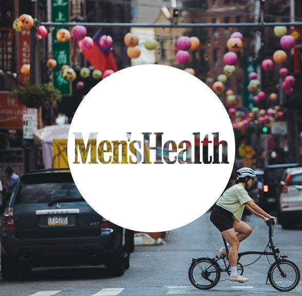 Men's Health logo in white circle over Brompton bicycle
