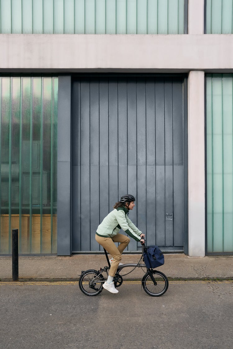 Person, die ein Brompton T-Line Fahrrad mit 12 Gängen fährt 