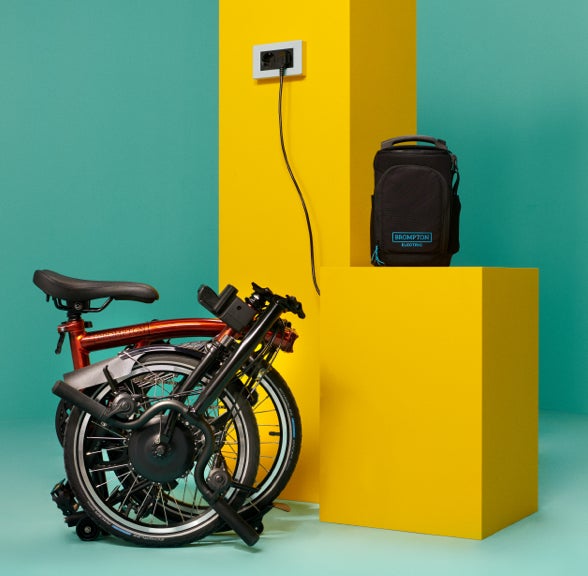 A studio shot folded Brompton Electric C Line charging