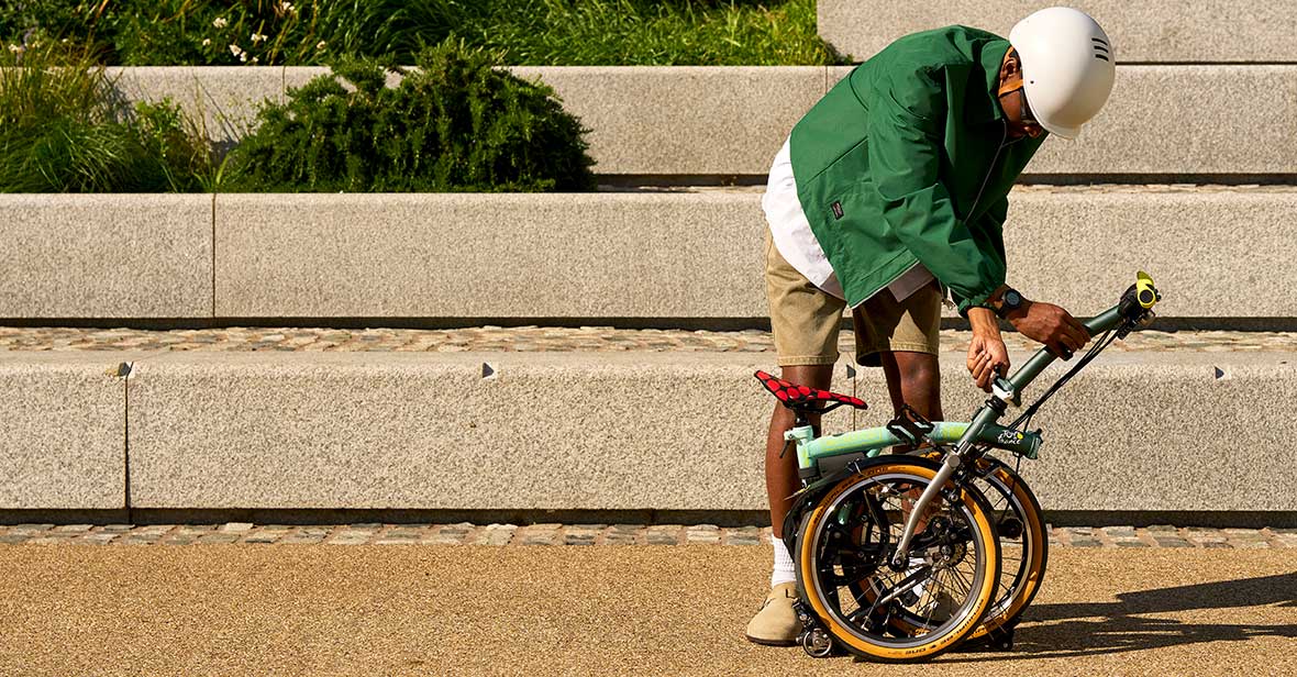 Man folding Brompton x Tour de France P Line by some stairs