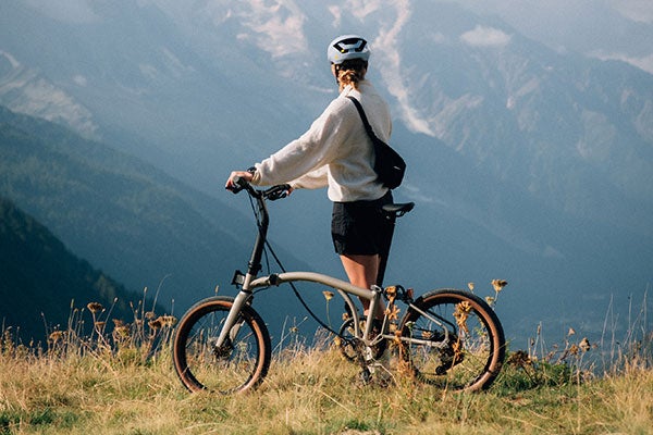 Person stood with Brompton G Line bike with a mountain view