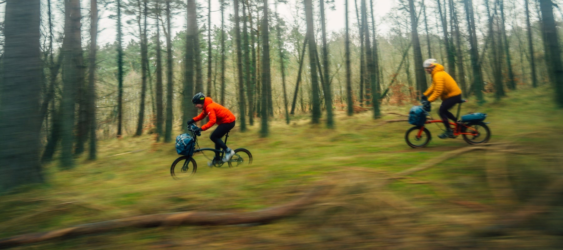 Two riders on G Line bikes in a forest