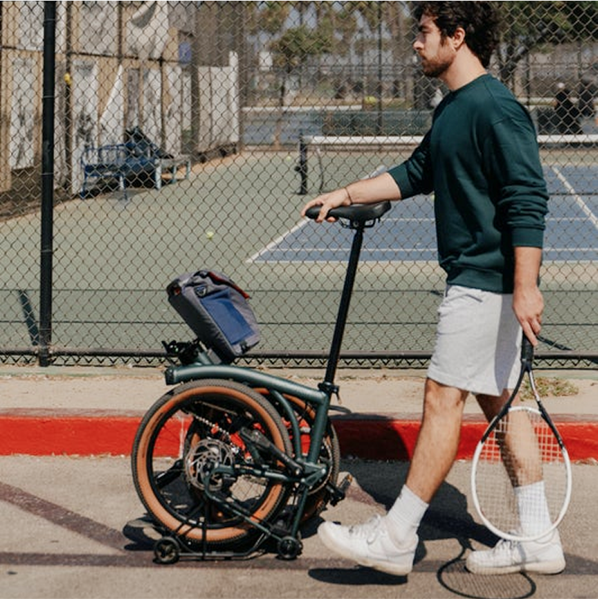 Ein Typ schiebt ein Brompton Electric G Line im SuperRoll+-Modus.