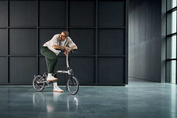 person riding brompton t line bike in a studio shot