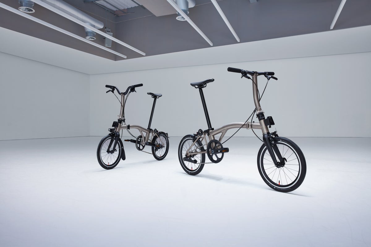 A studio shot of two Brompton T Line lightweight titanium folding bikes