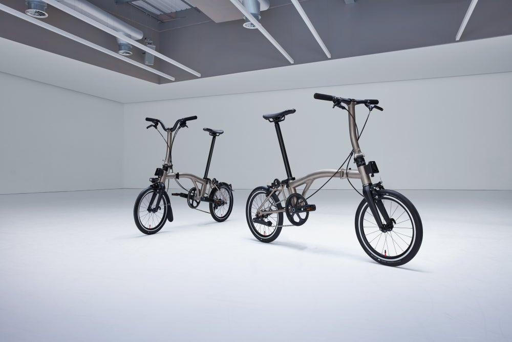 Eine Studioaufnahme von zwei Brompton-Falträdern der T Line aus leichtem Titan