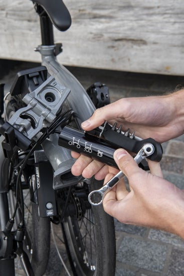 A person working on their Brompton with the Brompton toolkit