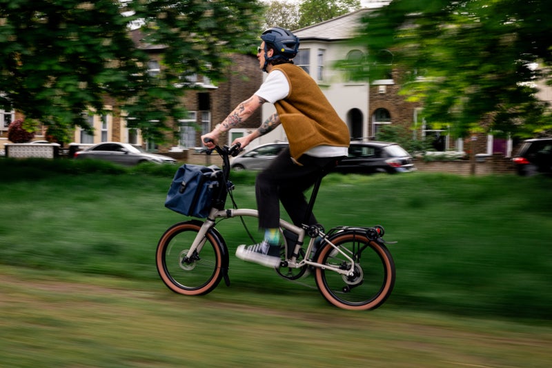 Person riding G Line bike through a park