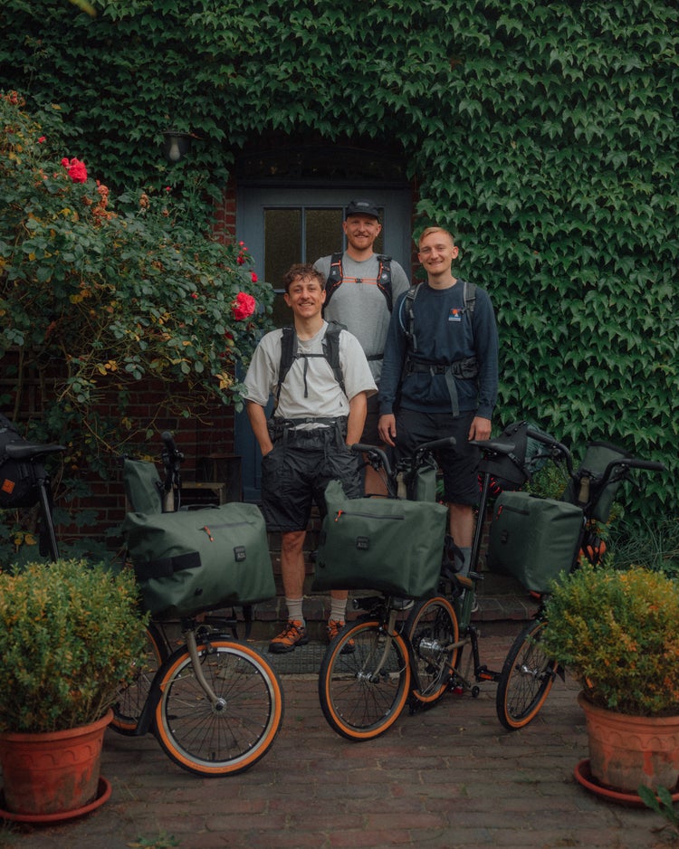 german roamers stood in front of house with brompton x bear grylls bike