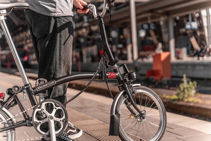 person with brompton bike on train platform