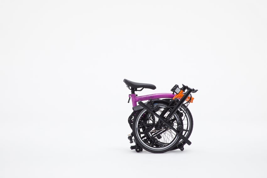 A folded purple and orange Kenzo x Brompton bike