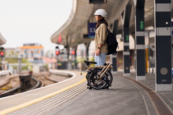 Person stood on train platform with Brompton bike