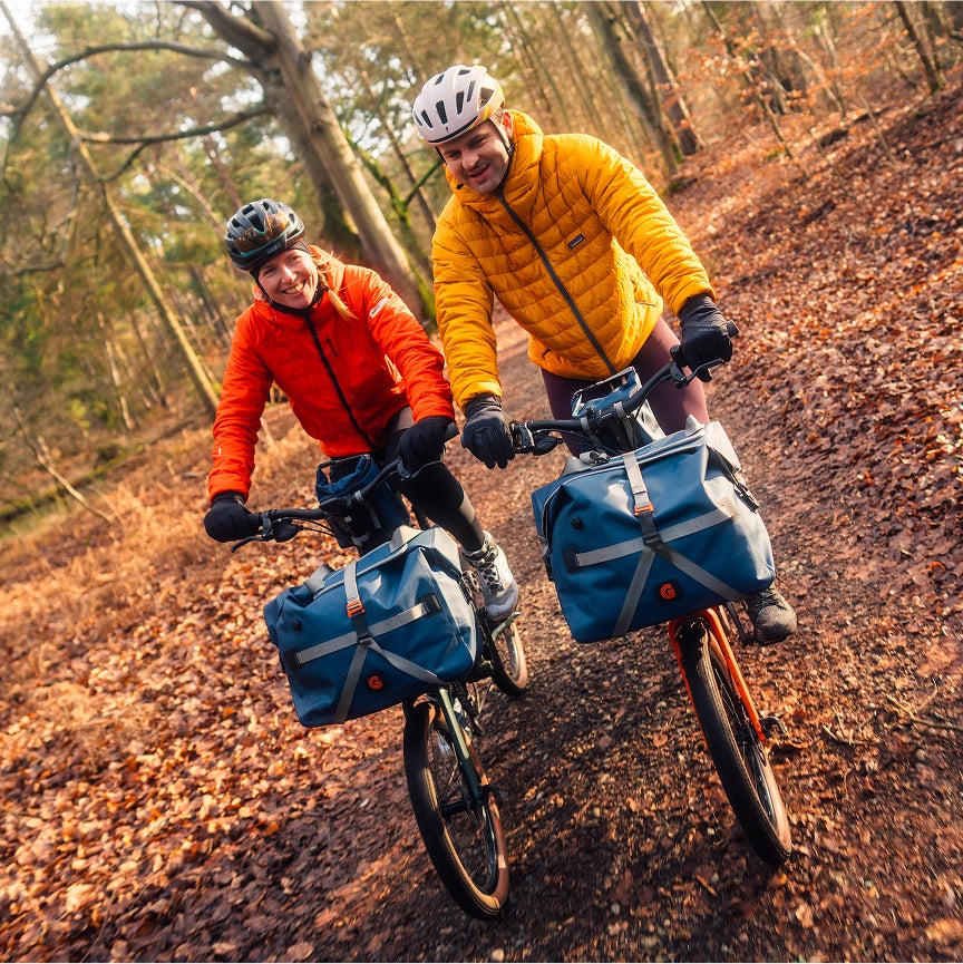 Zwei Leute, die mit G Line-Fahrrädern durch den Wald fahren