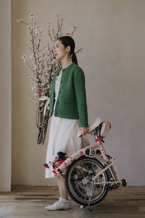 Person carrying Brompton Cherry Blossom folded bike