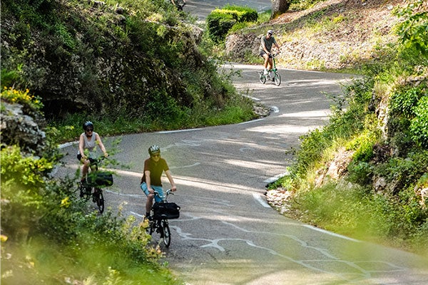 People riding Brompton bikes down a hill