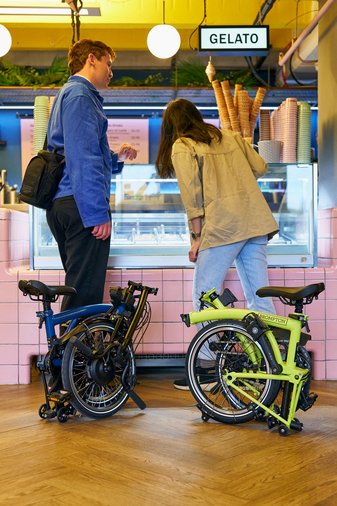 Una coppia di persone in una gelateria con le loro Brompton piegate.