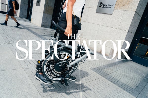The Spectator logo in white over Brompton bicycle