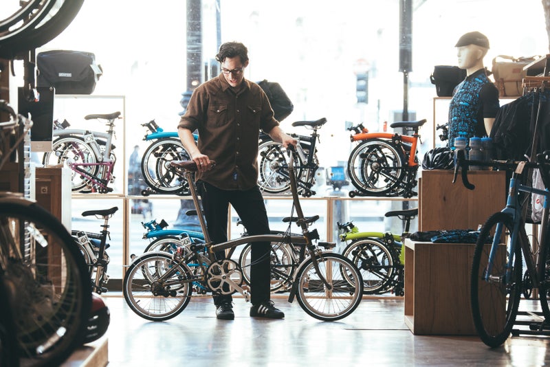 Une personne essayant un vélo Brompton en magasin