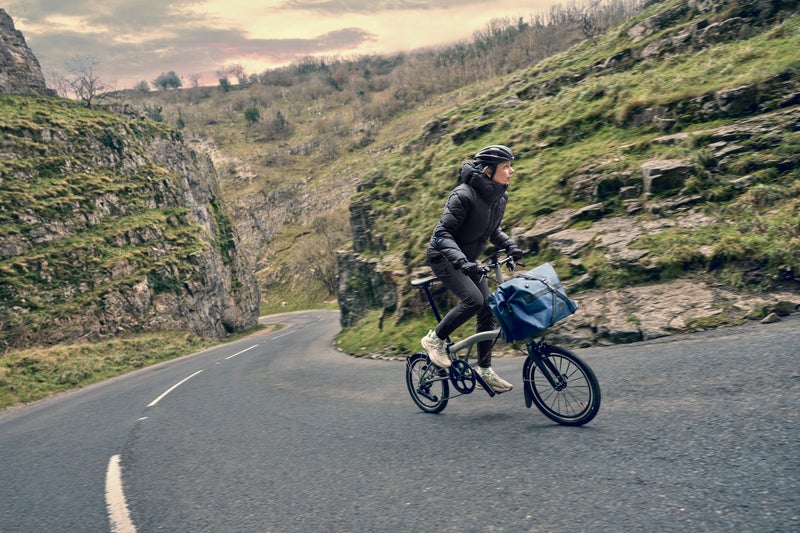 person riding a brompton t line 12 speed uphill