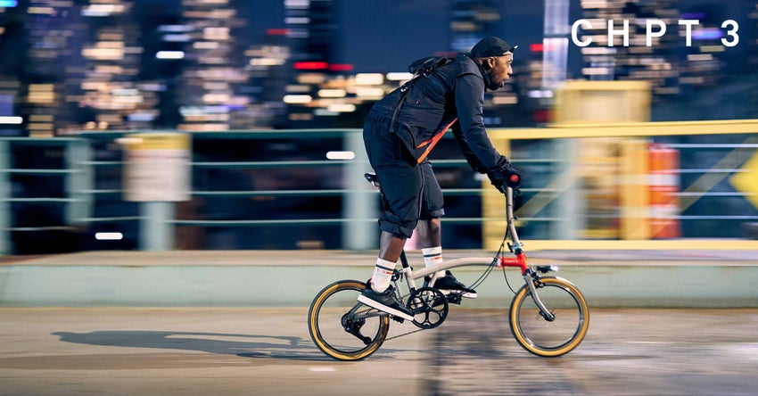 A person cycling a CHPT3 bike at night time.