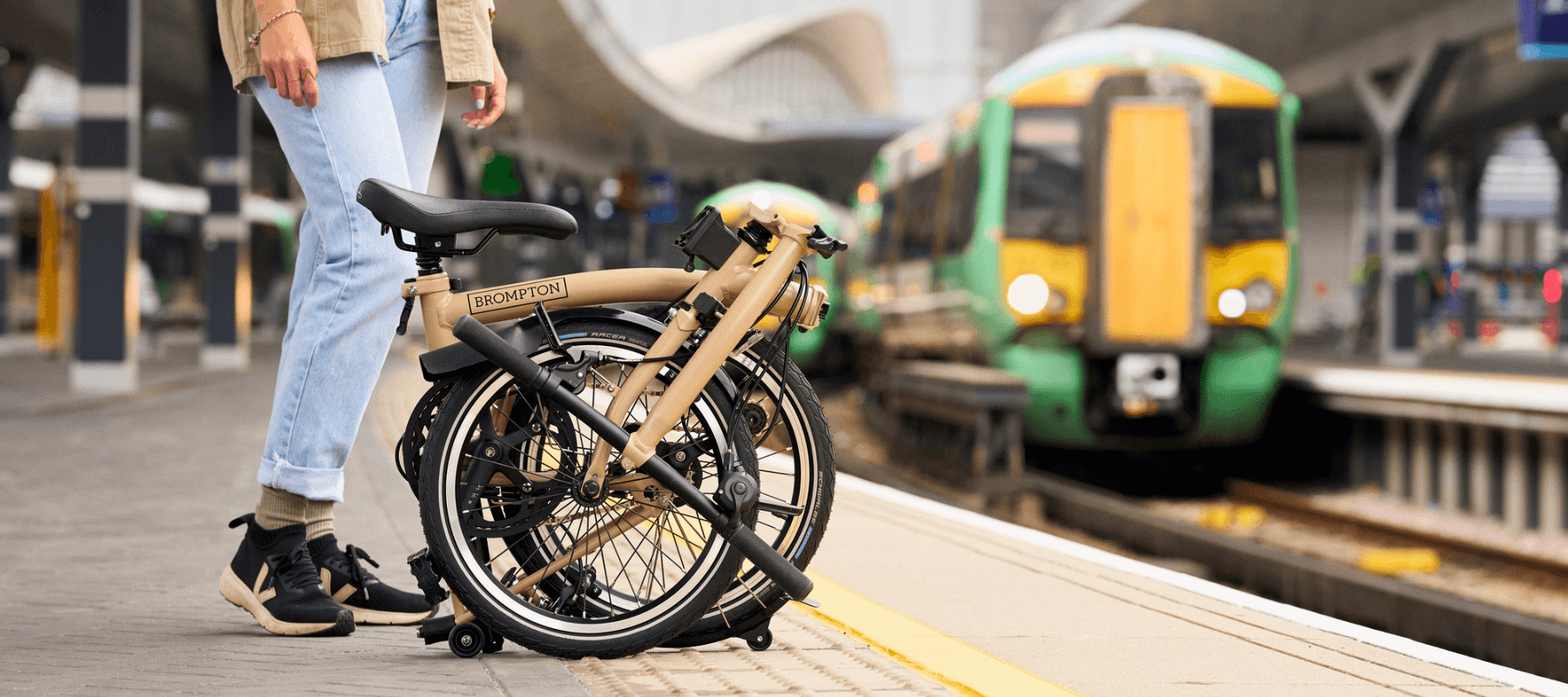 Person standing on train platform with a train sitting on the opposite platform