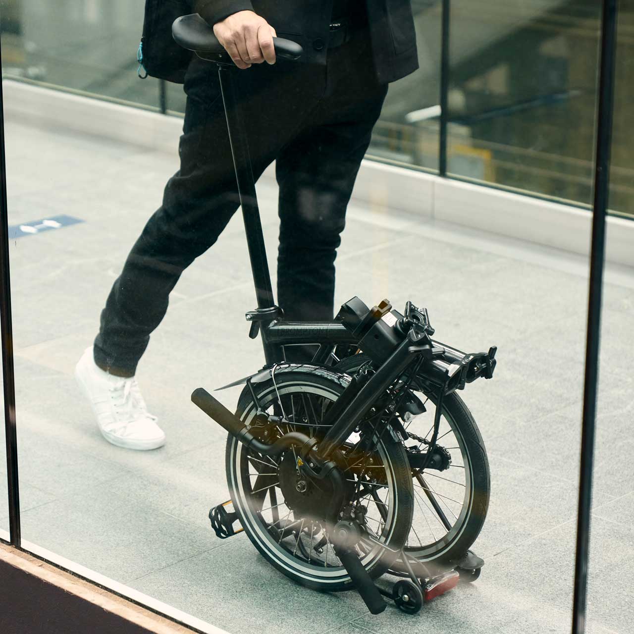 Person wheeling folded brompton
