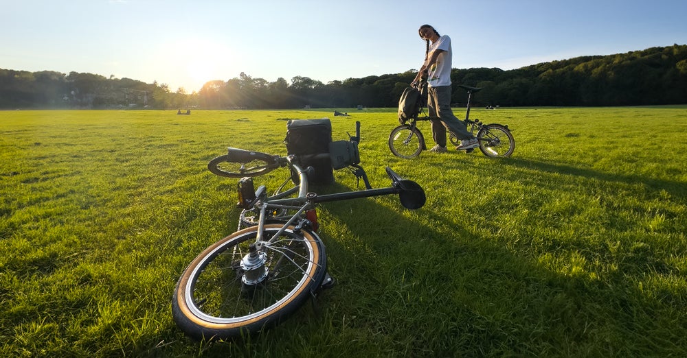An image of the Brompton x Bear Grylls folding bike laying in the grass