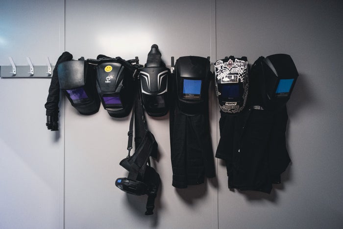 welding helmets hanging on a wall