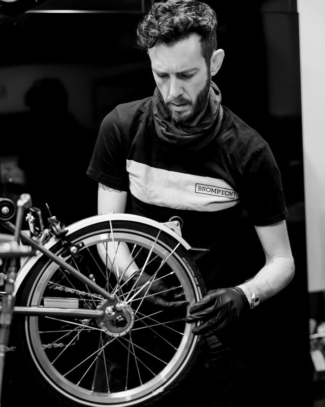 Person repariert Brompton-Fahrrad