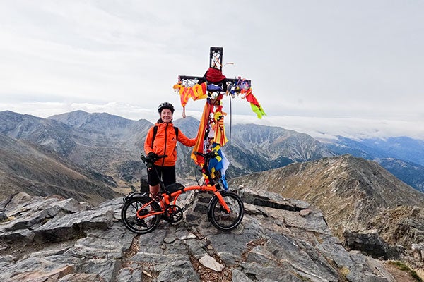 Person stood on top of mountain with Brompton G Line bike