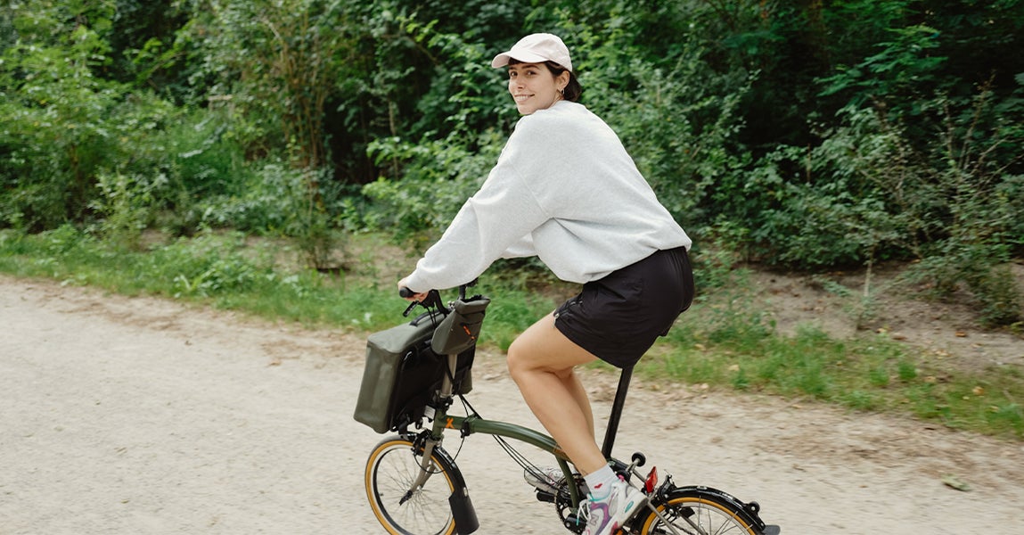 Content creator Lucy Bohr riding the Brompton x Bear Grylls folding bike