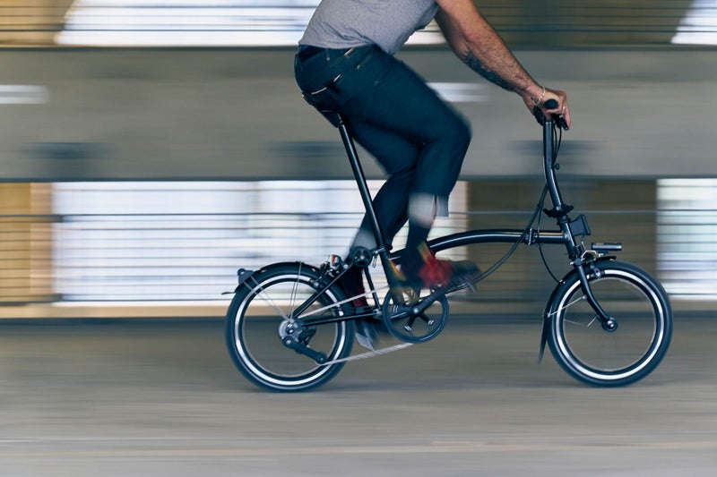 Un hombre posando con una Brompton P Line midnight black