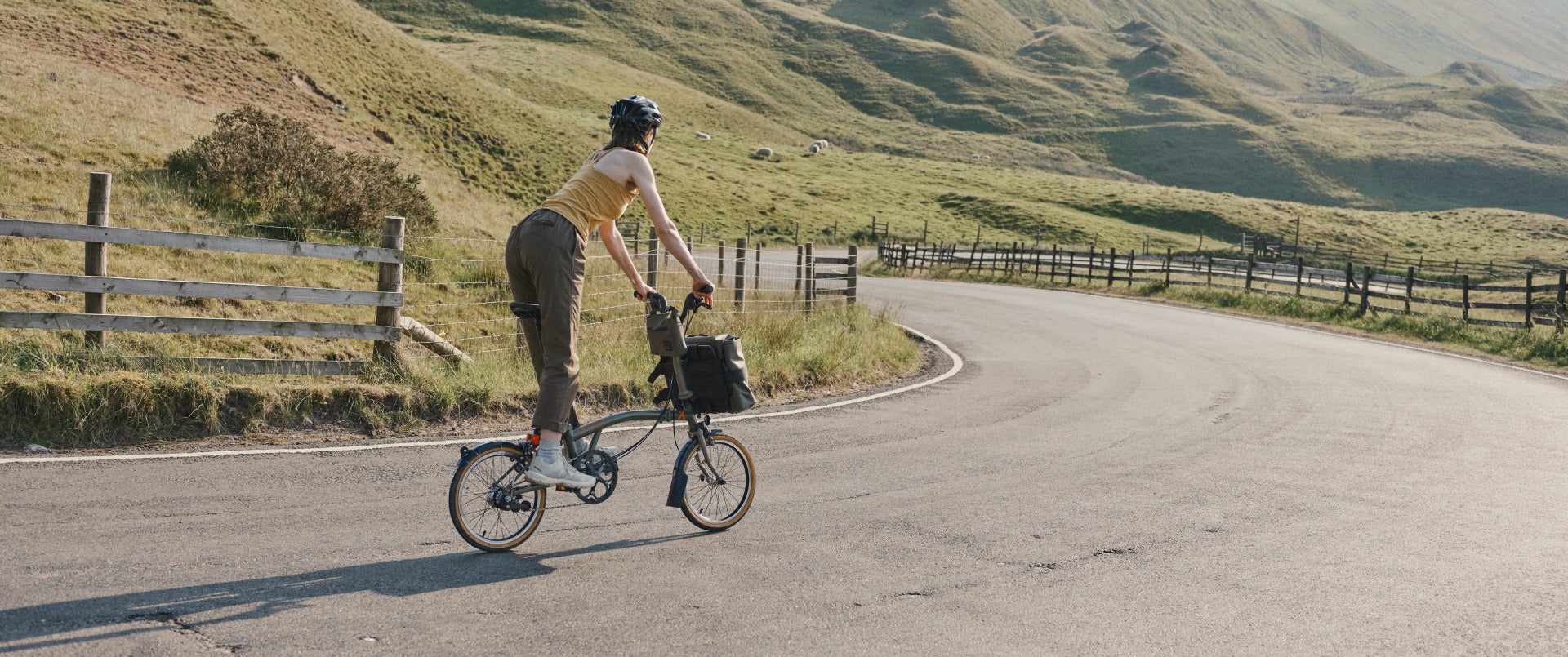 Een vrouw fietst op Bear Grylls Brompton Bike Collab