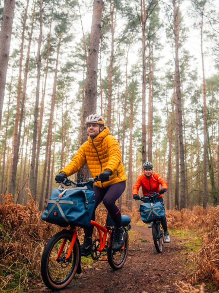 Two riders on G Line bikes in an autumnal forest