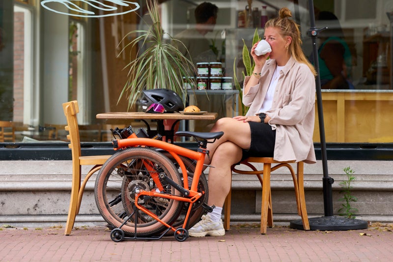 Person sat outside of a café with a Brompton G Line bike