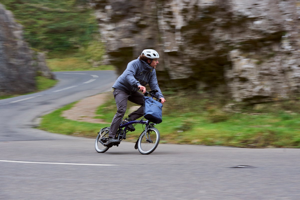 person riding brompton 12 speed p line up a hill