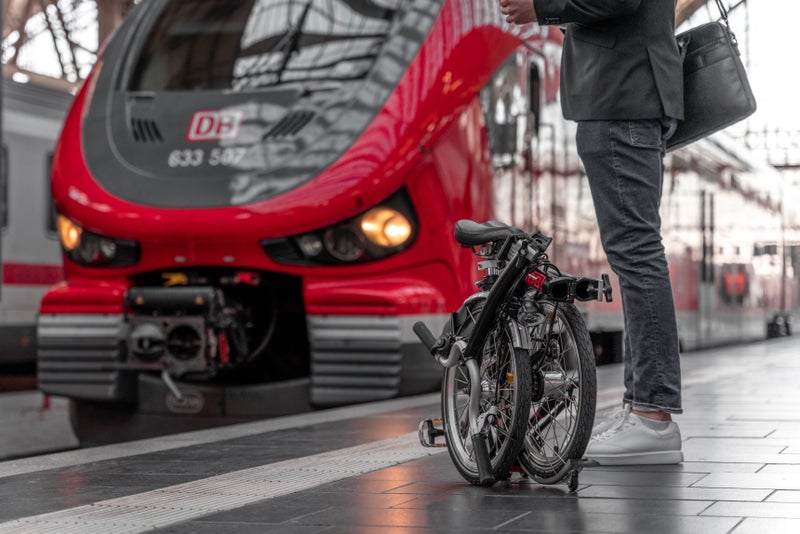 person with brompton bike in front of Deutschbahn