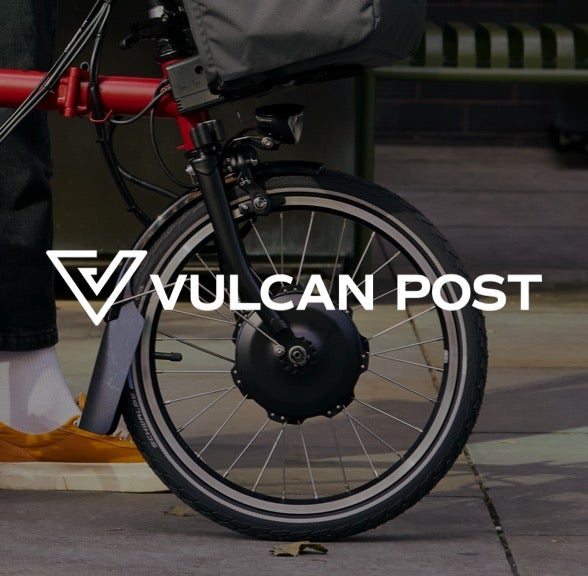 Vulcan Post logo in white over Brompton bicycle