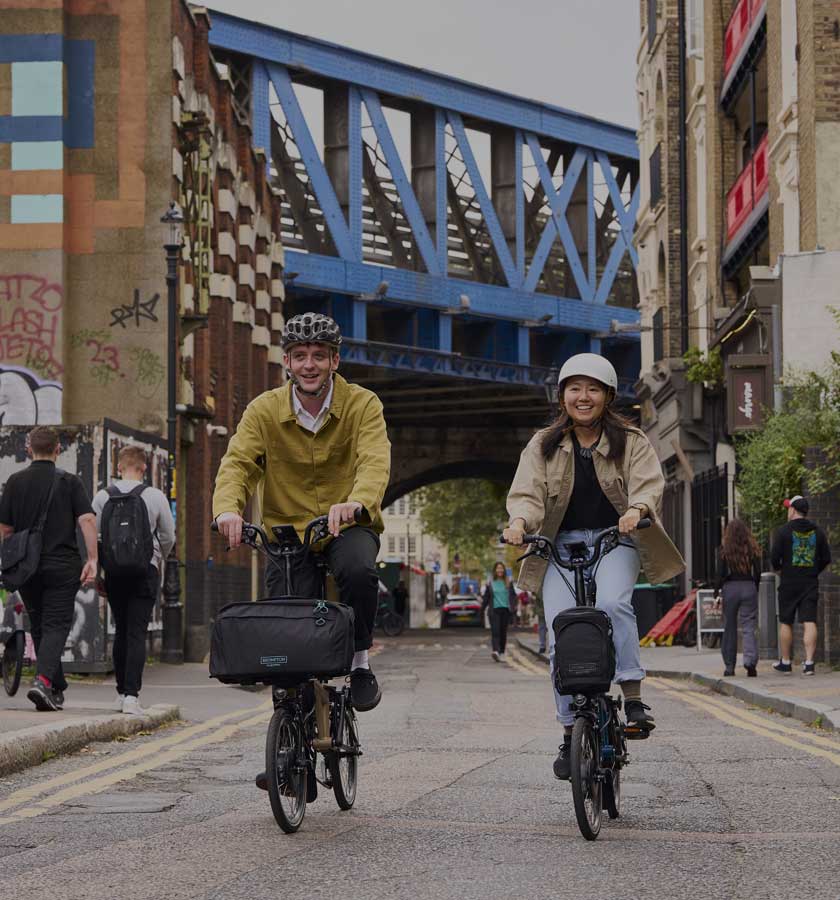 Man and woman riding Brompton bikes