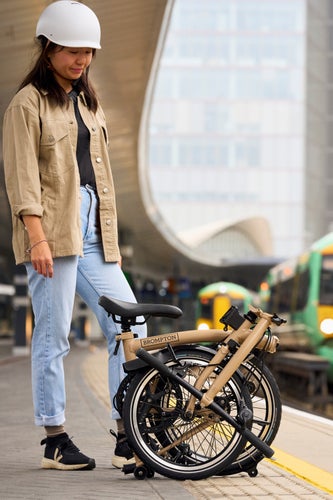 A model with the Brompton C Line in Dune Sand folded down