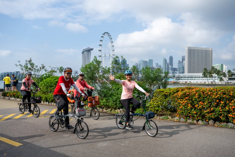 A group of happy cyclists on Brompton folding bikes in Singapore