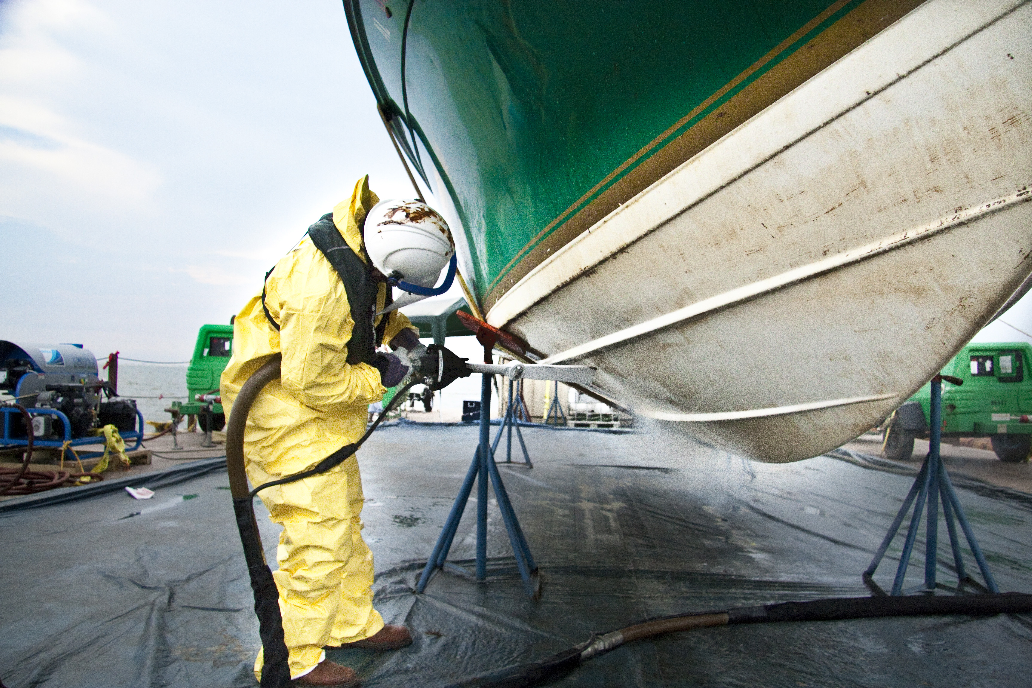 Trabalhador realizando limpeza criogénica por empreitada em casco de embarcação para remoção de contaminantes marinhos