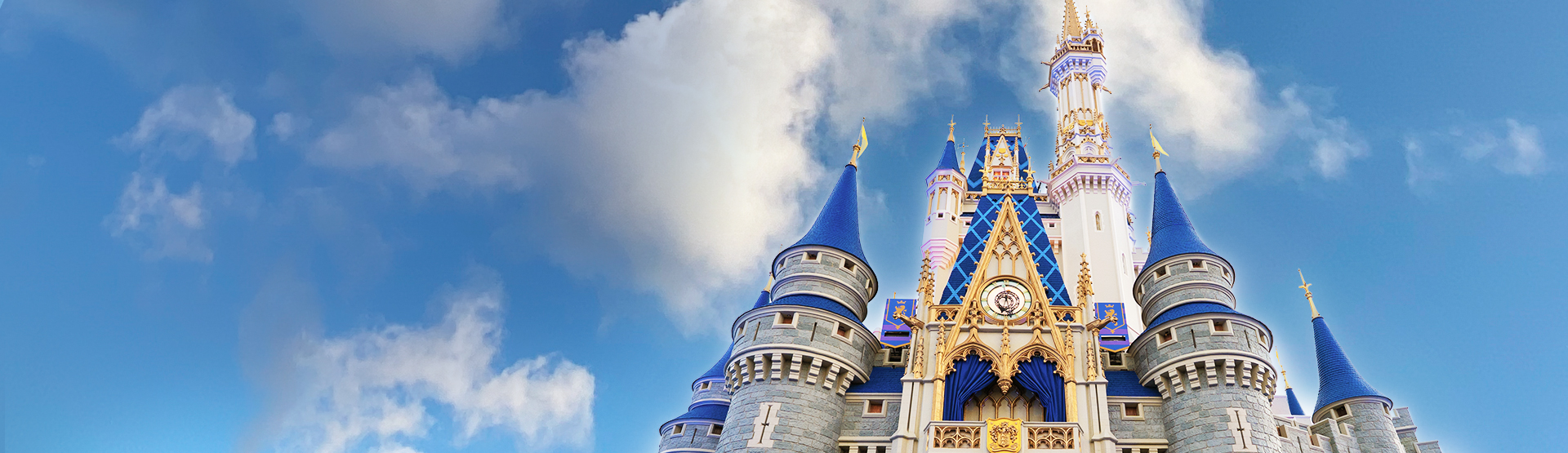 Image of the Cinderella Castle at Walt Disney World, taken from the ground, with blue spires and stone towers against the clear sky.